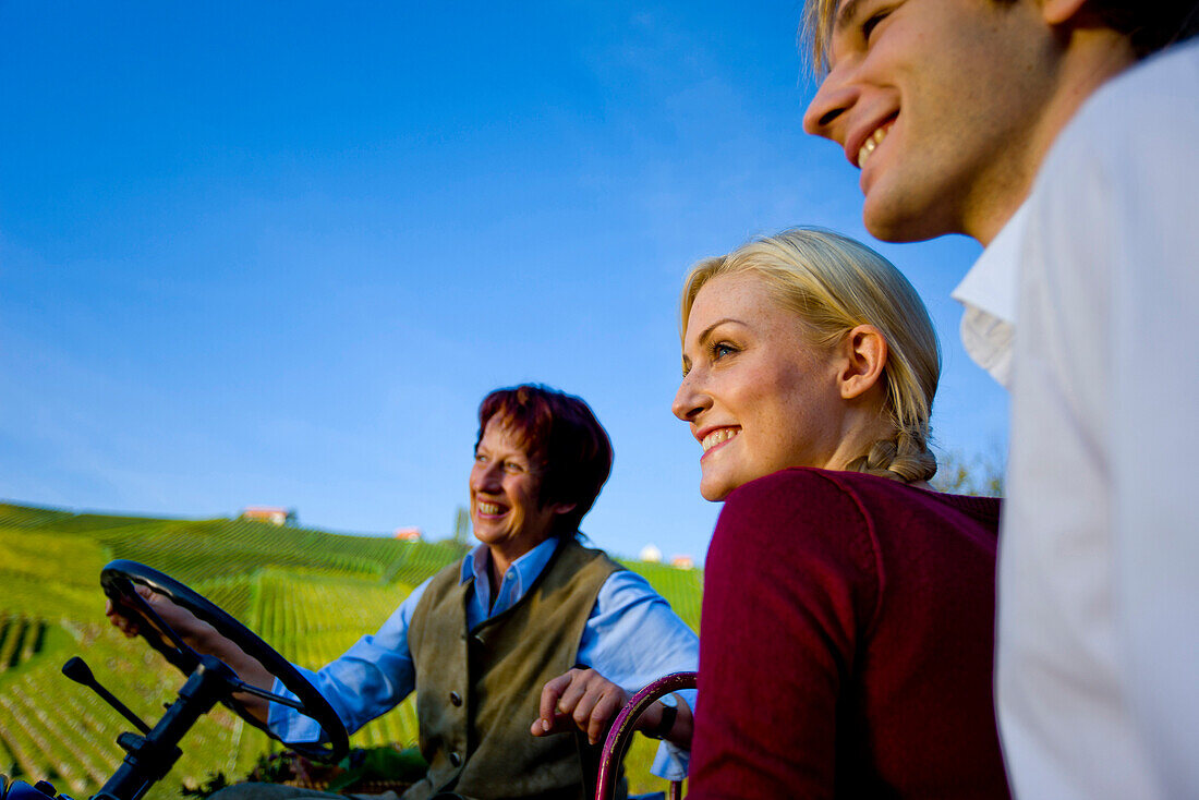 Farmer on a tractor talking with a couple, Styria, Austria