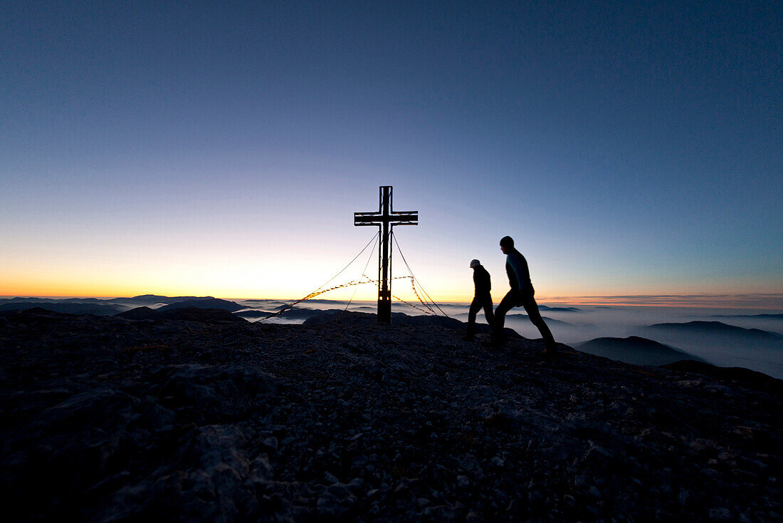 Zwei Wanderer am Hochschwabgipfel bei Sonnenaufgang, Hochschwab, Steiermark, Österreich
