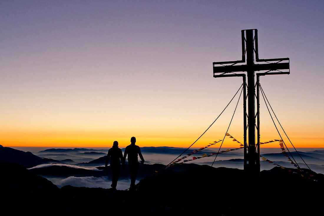 Zwei Wanderer am Hochschwabgipfel bei Sonnenaufgang, Hochschwab, Steiermark, Österreich