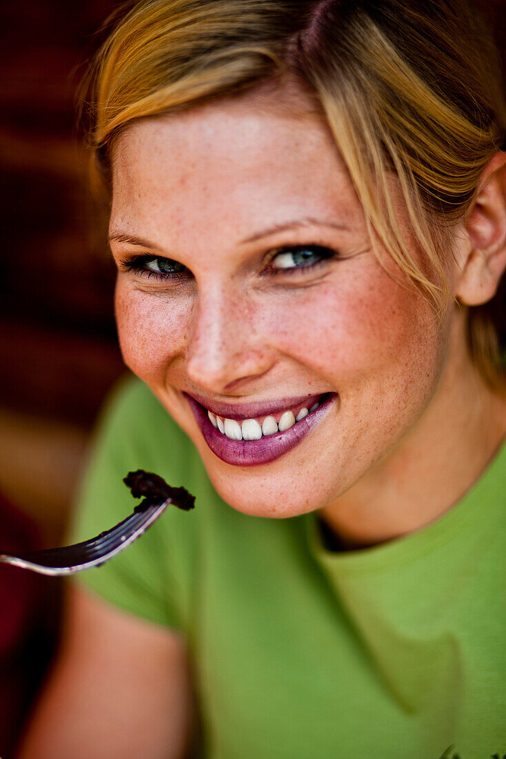 Young woman eating pancake with blueberries, lake Duisitzkar, Styria, Austria