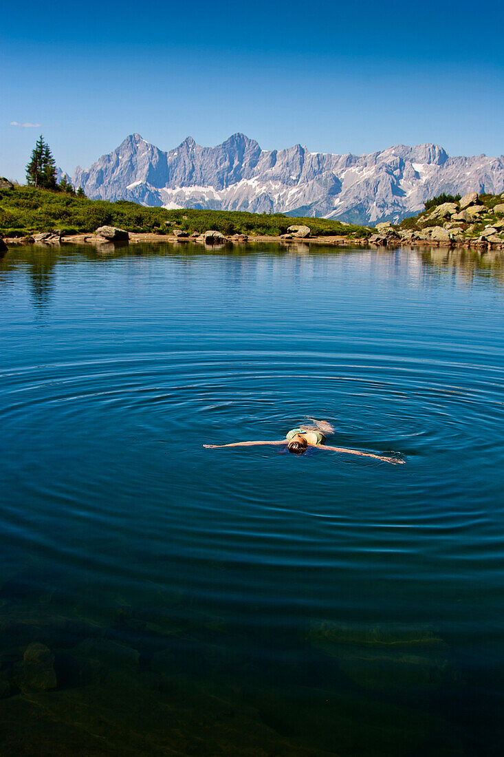 Person badet im Spiegelsee, Dachsteingebirge im Hintergrund, Steiermark, Österreich