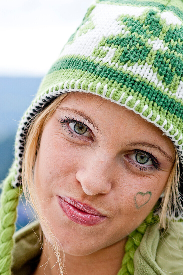 Young woman wearing a woolly hat looking at camera, Styria, Austria
