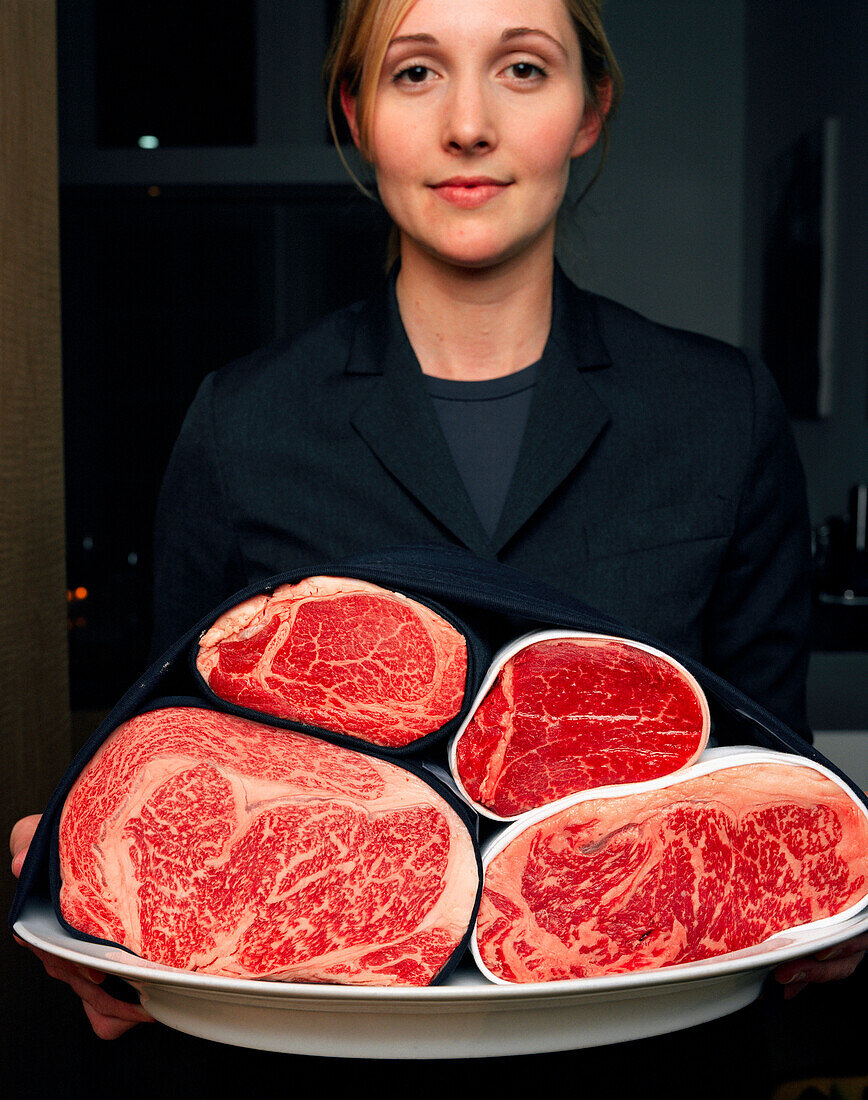 USA, California, Los Angeles, young waitress standing holding the meat tray at CUT Restaurant.