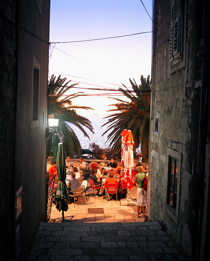CROATIA, Korcula, Dalmatian Coast, people sitting at an outdoor restaurant in Korcula at night.