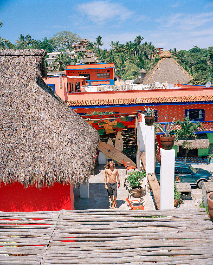 MEXICO, Sayulita, young man standing outside house, elevated view