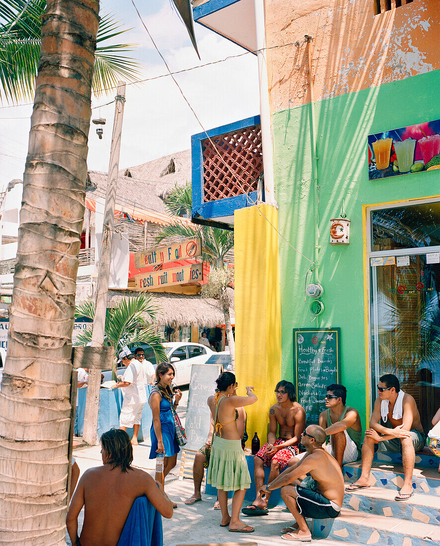 MEXICO, Sayulita, group of friends in conversation outside building