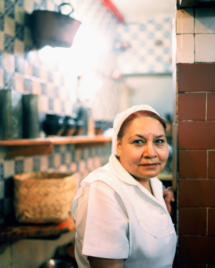 MEXICO, Mexico City, female chef standing in kitchen of Fonda El Refugio.