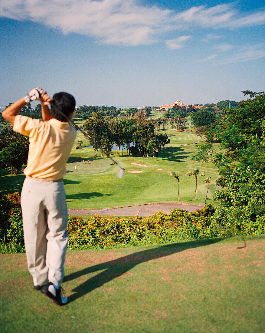 SINGAPORE, Asia, rear view of man playing golf at Sentosa Resort