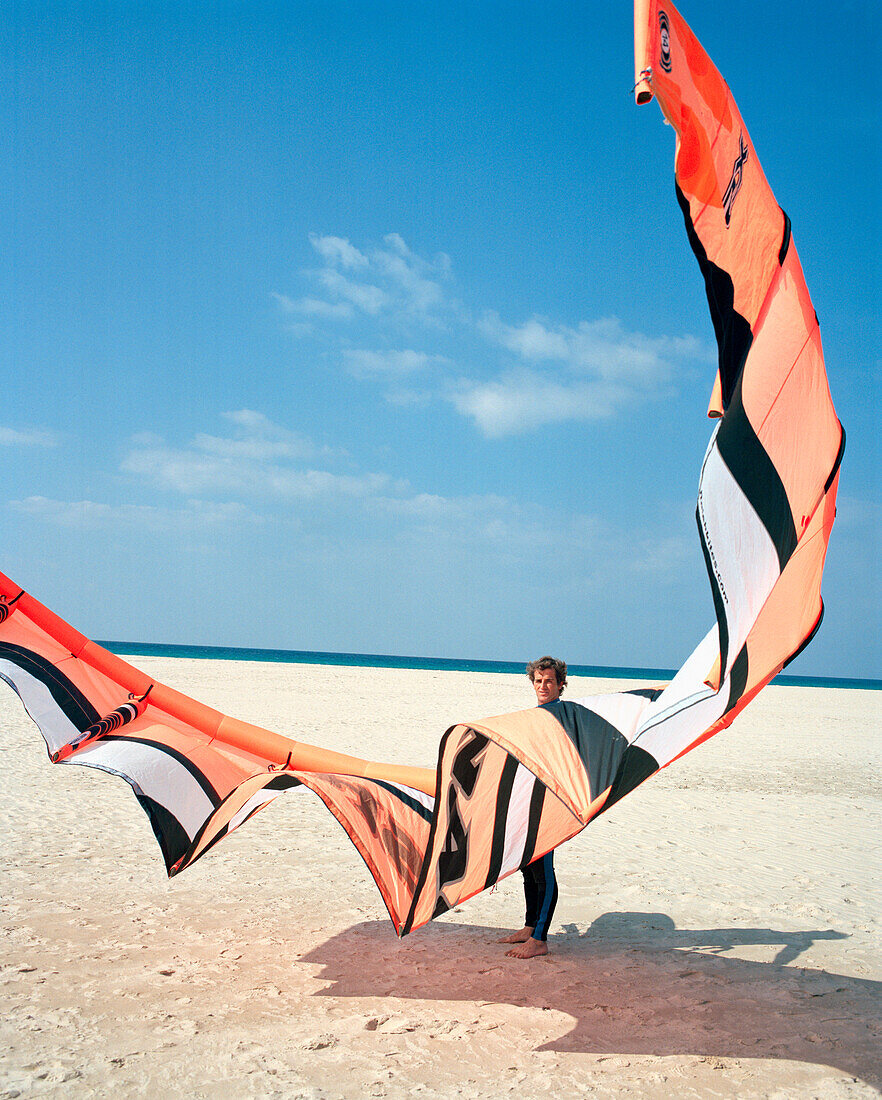 SPAIN, Andalusia, Tarifa, man with kite surfing gear on beach