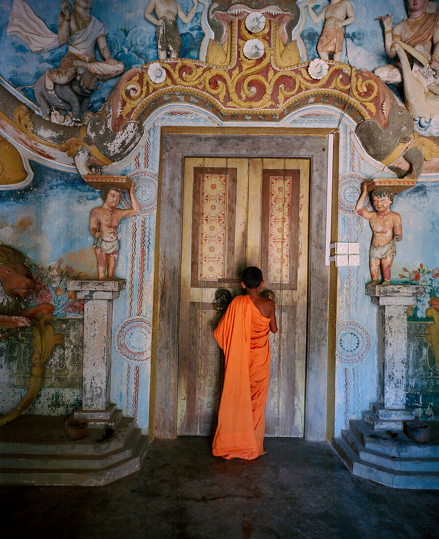 SRI LANKA, Asia, rear view of a monk standing in front of temple's door