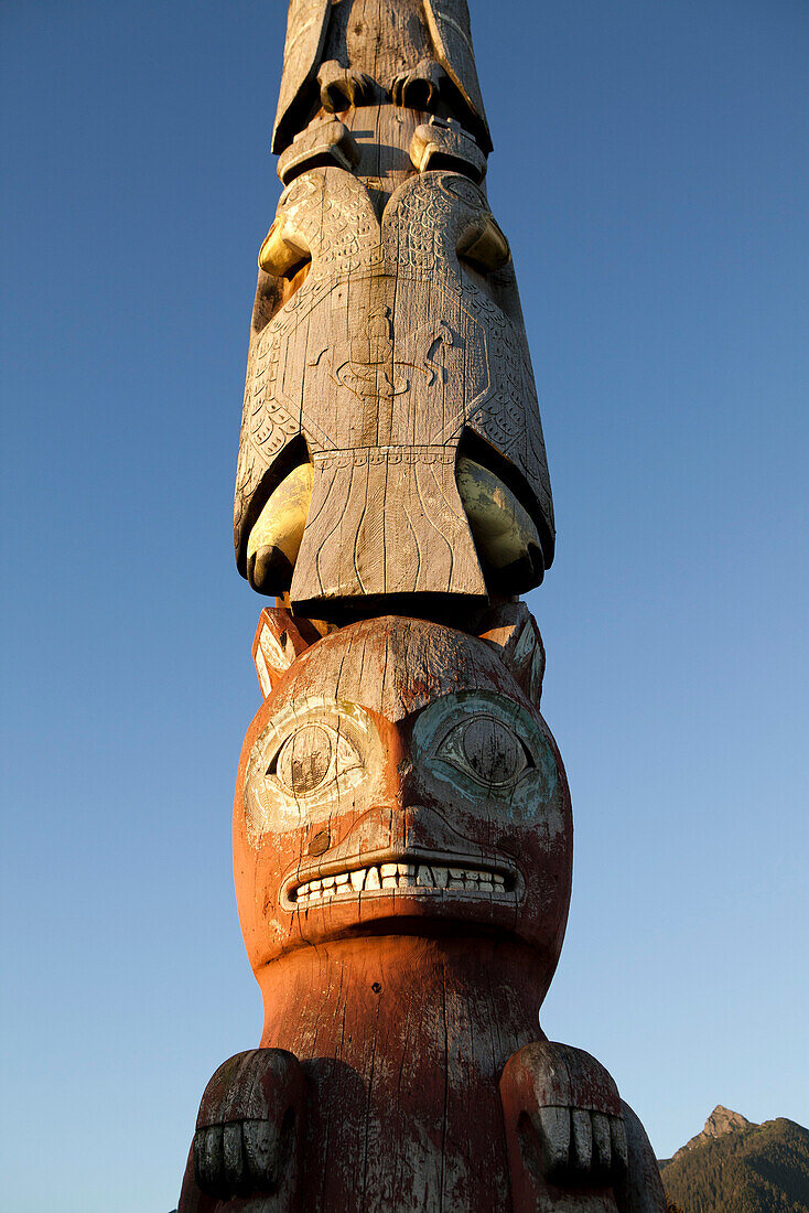 ALASKA, Sitka, details of an old totem pole that stands in the center of town on the edge of Sitka Harbor