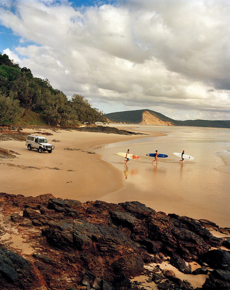 AUSTRALIA, Queensland, Noosa Heads, surfers explore 40 mile beach to find some waves