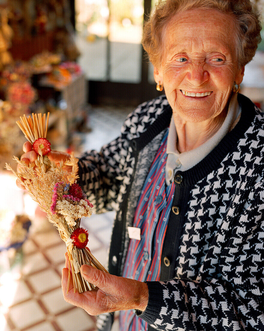 AUSTRIA, Weiden Am See, Magdalena Horvath at her farm stand sells wheat and dried flower arrangements, Burgenland