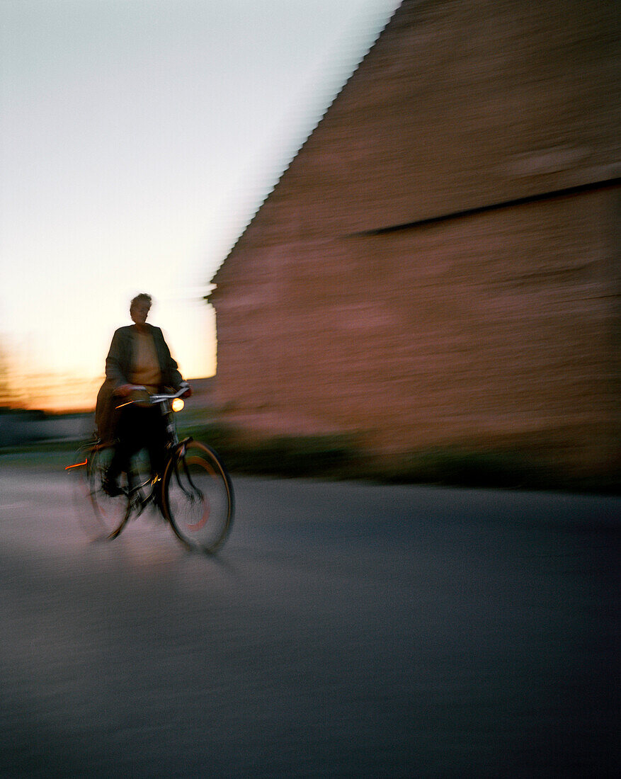 AUSTRIA, Podersdorf, a woman rides her bicycle in the early morning, Burgenland