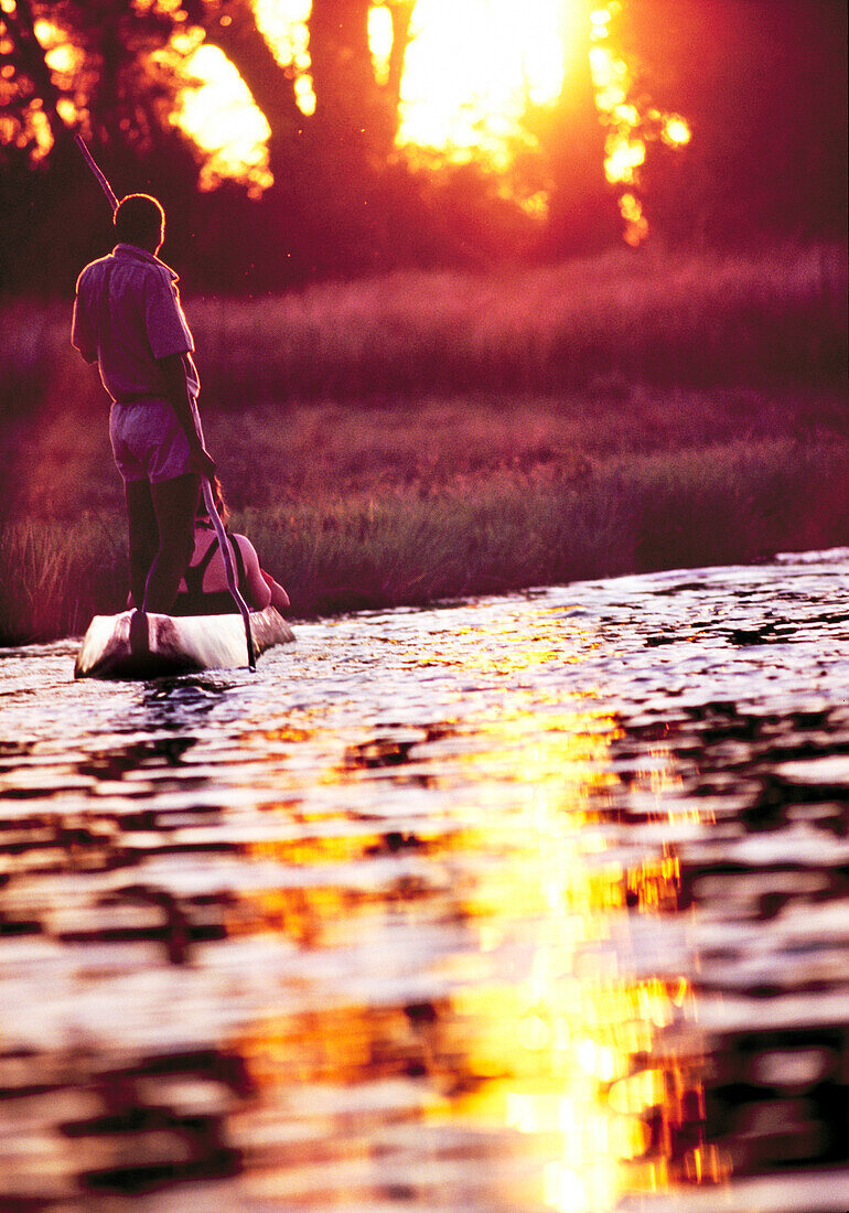 BOTSWANA, Africa, Okavango Delta, Sunset on the Okavango River in a Dugout Canoe