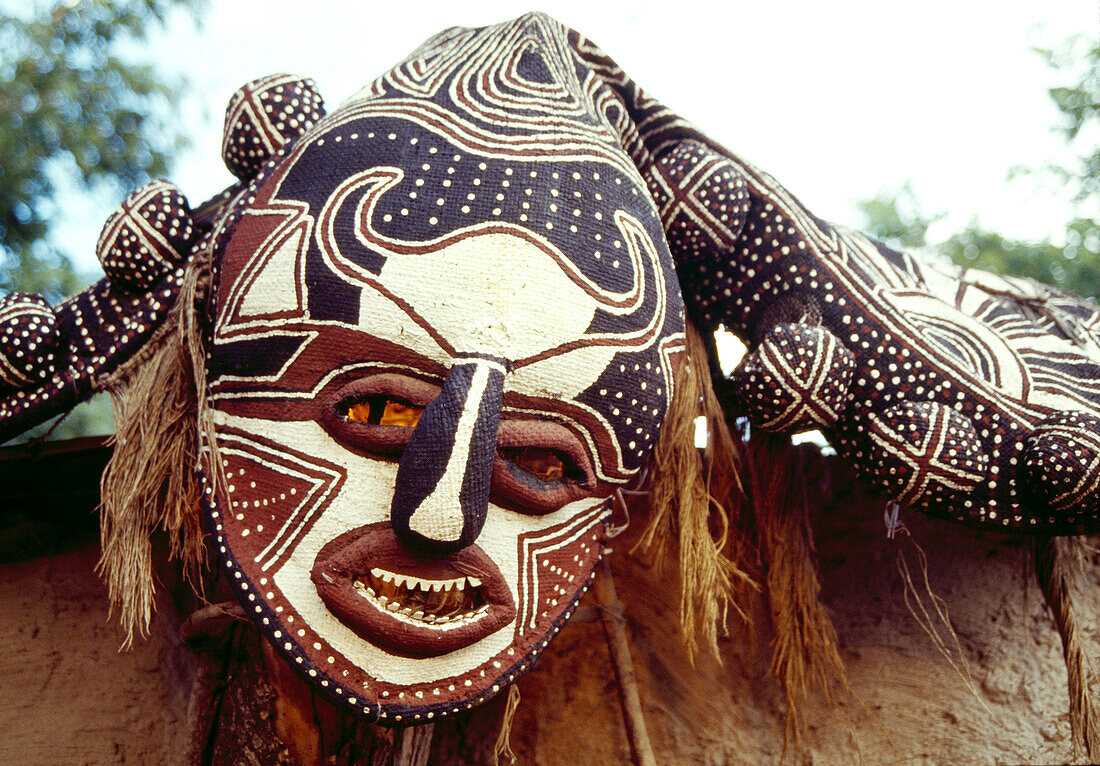 BOTSWANA, Africa, a ceremonial mask hanging near the entrance of a mud hut, Okavango Delta