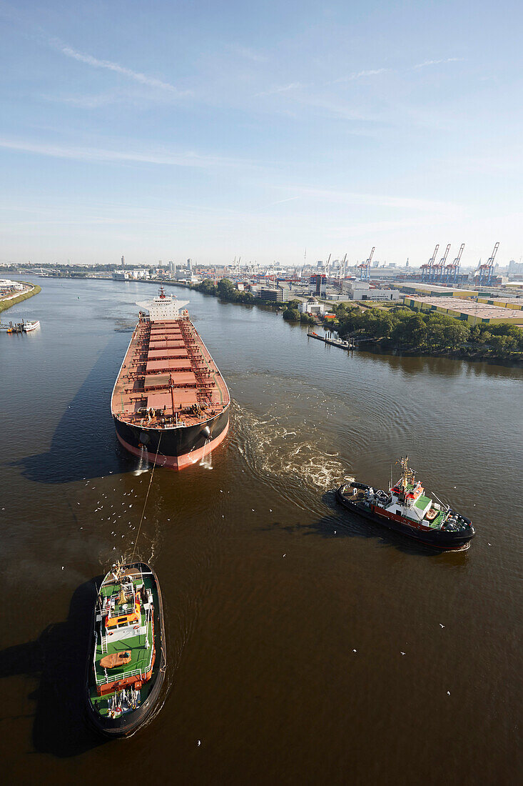 Tanker with tug boats on the river Elbe near Waltershof, Hamburg, Germany