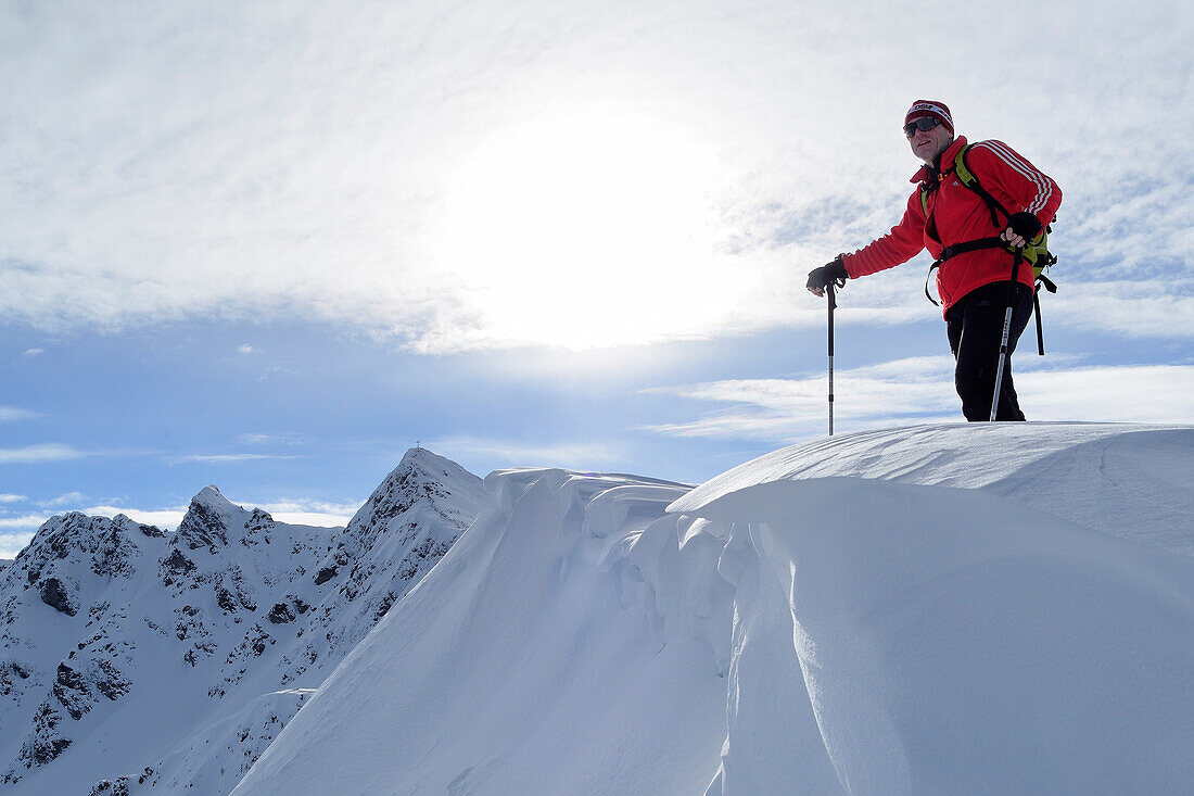 Skitourengeher steht an einem Wechtengrat, Sagtaler Spitzen, Kitzbüheler Alpen, Tirol, Österreich