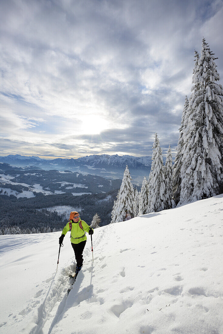 Skitourgeherin steigt zum Kranzhorn auf, Kaisergebirge im Hintergrund, Chiemgauer Alpen, Tirol, Österreich
