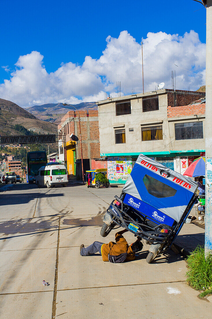 Mann repariert eine Motorradtaxi, Huaraz, Ancash, Peru