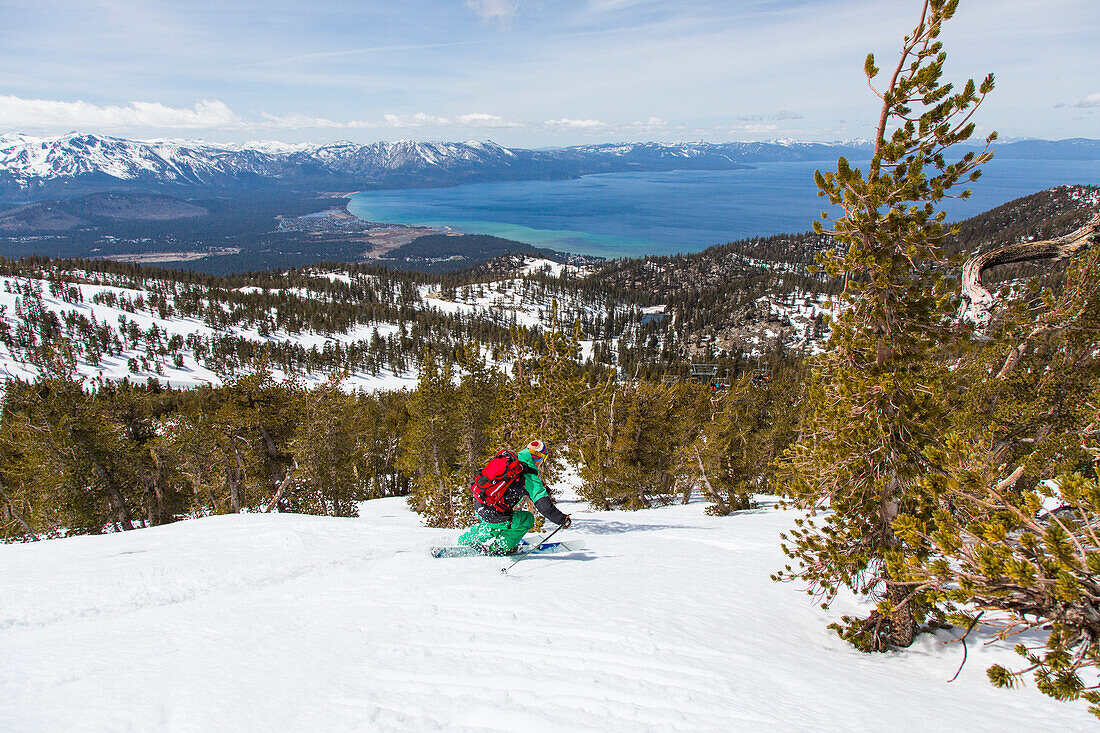 Man downhill skiing, Lake Tahoe in background, Heavenly ski resort, California, USA
