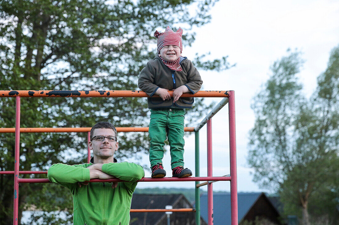 Father and son at a climbing frame, lake Carwitz, Conow, Feldberger Seenlandschaft, Mecklenburg-Western Pomerania, Germany