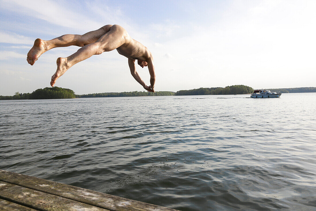 Mann springt nackt in einen See, Lychen, Naturpark Uckermärkische Seen, Uckermark, Brandenburg, Deutschland