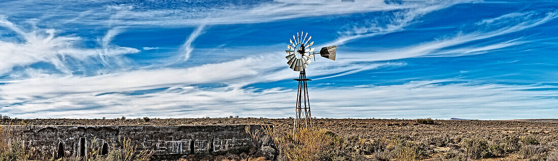 Africa, South Africa, Great Karoo. water reservoir on a farm with westernmill for pumping out water, cattle watering place. Afrika, Suedafrika, Grosse Karoo. Wasserreservoir auf einer Farm mit Western-Windrad zum Wasser pumpen, Viehtränke.