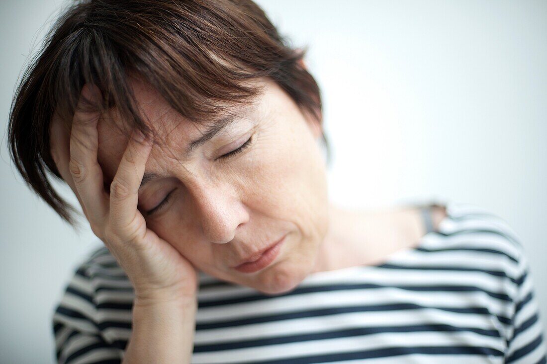 mujer con las manos tapando la cara preocupada, woman with her hands covering her face worried