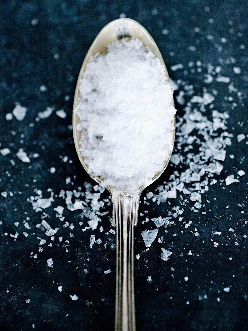 Close up of spoon of sea salt. Flaky sea salt