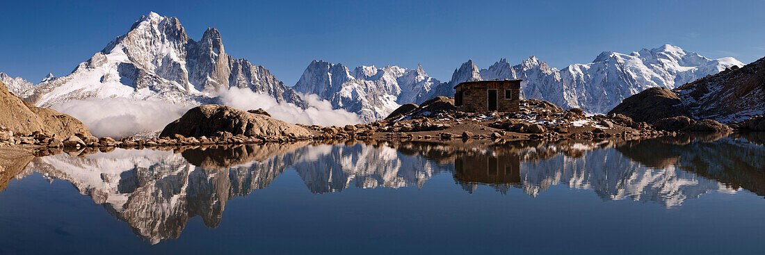 Panorama der Savoyer Alpen mit Spiegelung im Bergsee Lac Blanc und den Gipfeln Aiguelle Verte, Grande Jurasse, Aiguille du Midi und Mont Blanc im Herbst, Chamonix Tal, Haute-Savoie, Frankreich