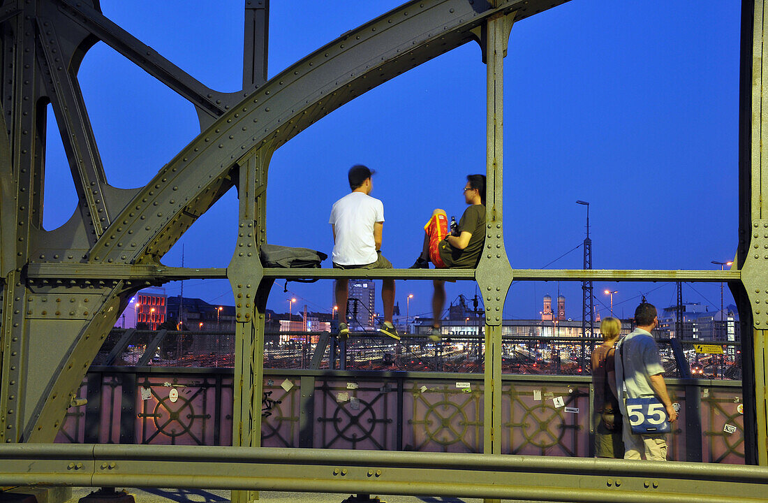 People sitting on the Hacker bridge in the evening, Munich, Bavaria, Germany