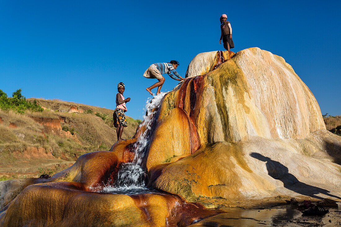 Madagassische Kinder beim Spielen, spuckender Geysir, Geysire von Ampefy, Hochland, Madagaskar, Afrika