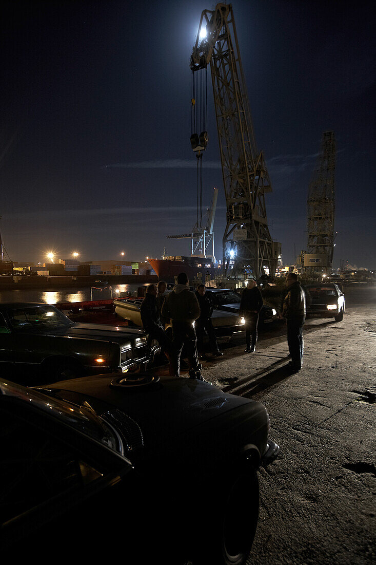 Motoraver group with modern classic cars meeting in harbor at night, Hamburg, Germany