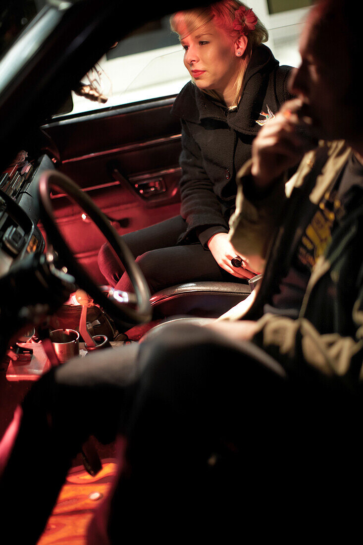 Couple sitting in side a modern classic car, Motoraver group, Hamburg, Germany