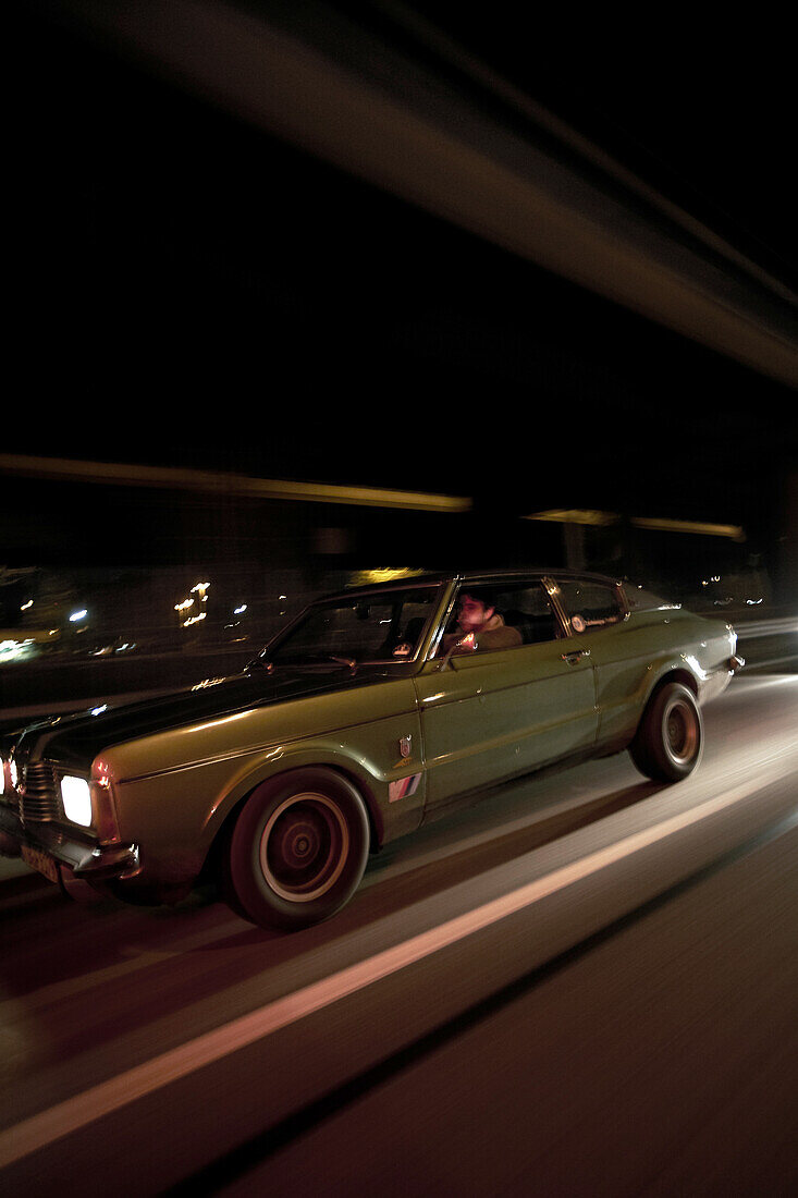 Mann fährt in einem Youngtimer bei Nacht, Motoraver, Hamburg, Deutschland