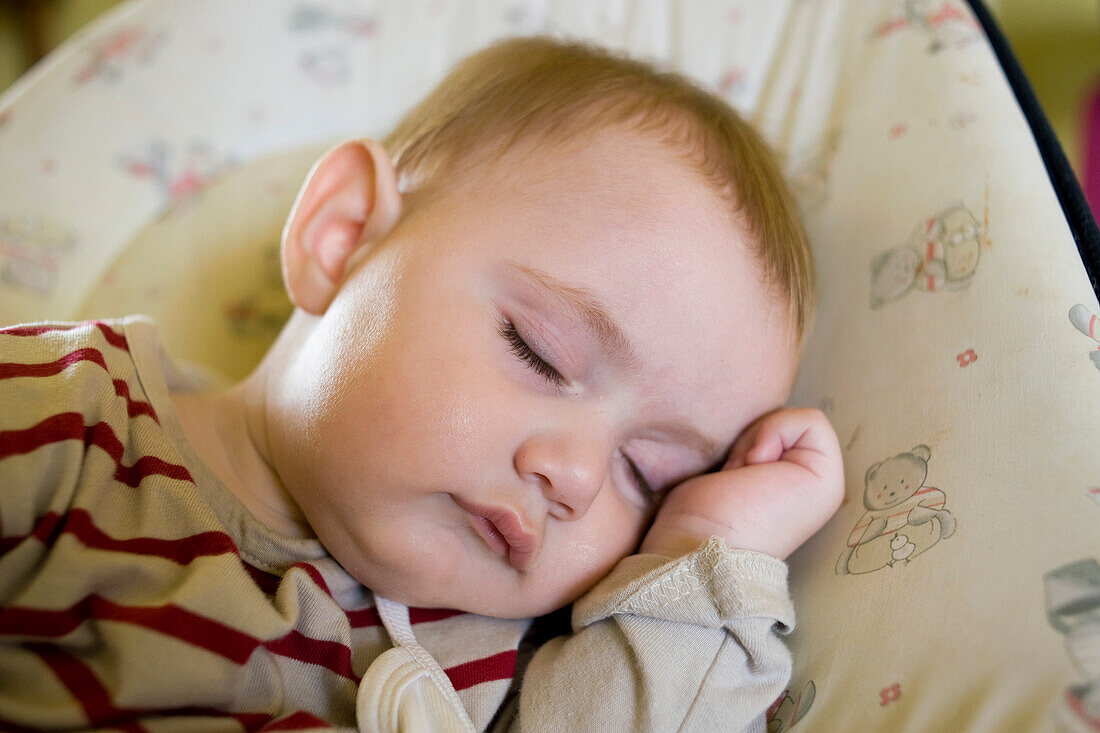 Close up of a baby sleeping his hand under his head