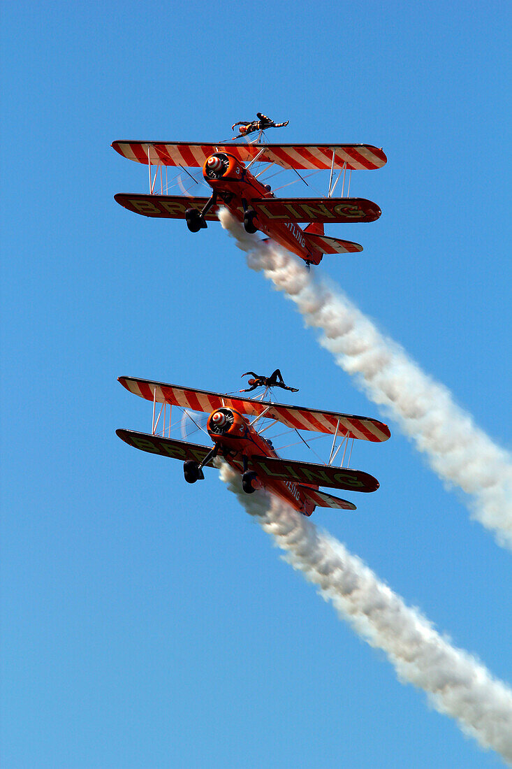 France, Essonne, La Ferte Alais, Airshow 2012. Wing Walkers on Stearman aircraft in full aerobatics.