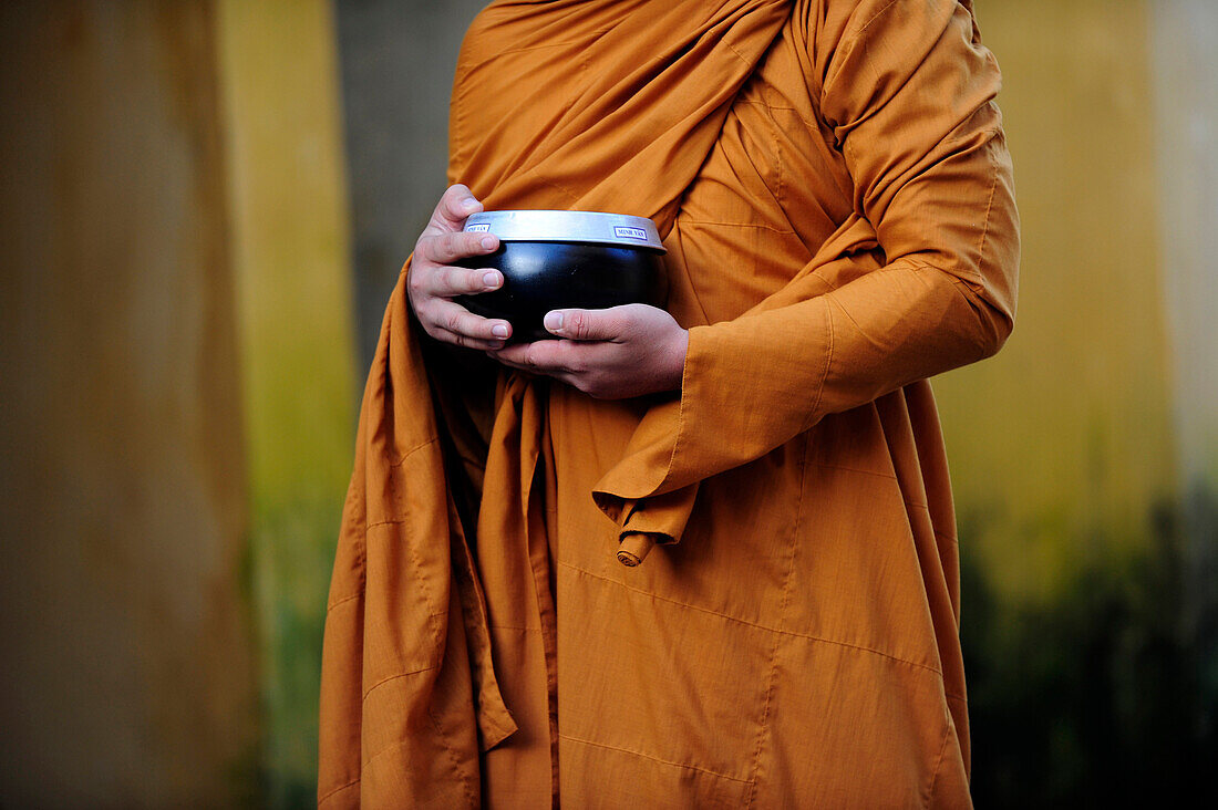 Monk with alms bowl waiting for alms in Hoi An, Central Vietnam, Vietnam, South East Asia, Asia