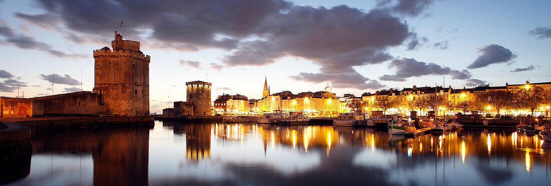 France. Charente Maritime. La Rochelle. The tower chain and the Saint Nicolas tower and the old port during the twilight.