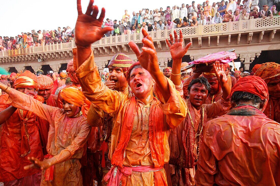 Barsana villagers celebrating Holi in Nandgaon, taunting Nandgaon villagers who throw colored fluids over them Nandgaon. India.