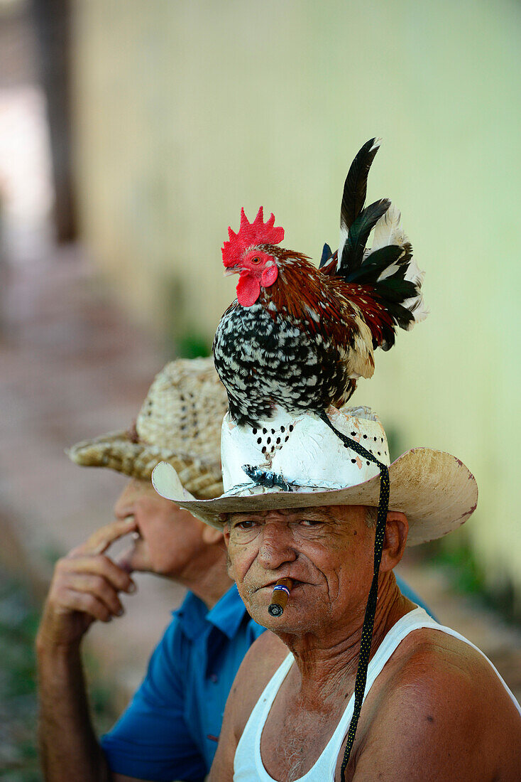 Man with colorful chicken on head