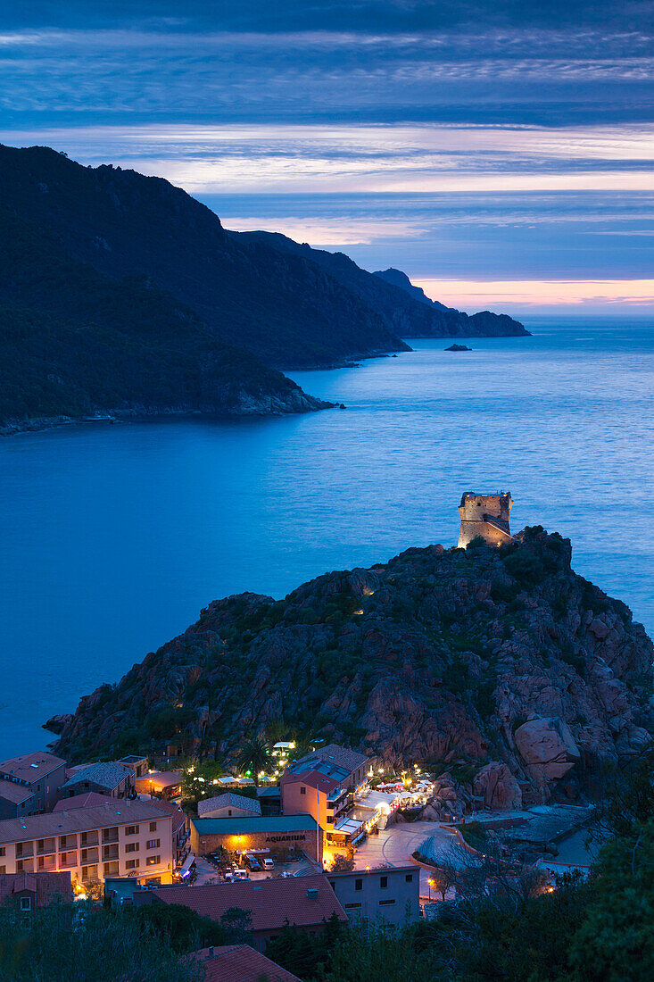 France, Corsica, Corse-du-Sud Department, Calanche Region, Porto, elevated view of town and Genoese tower, dusk
