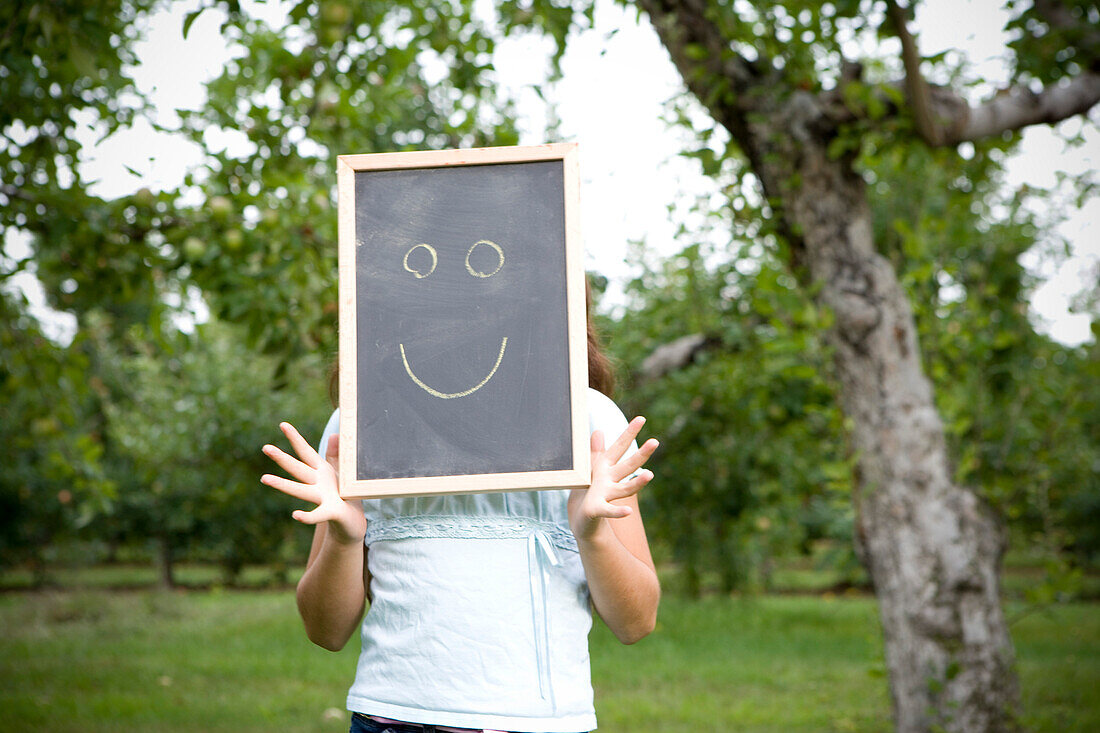 Girl on Apple Farm holding Chalkboard with Smiley Face