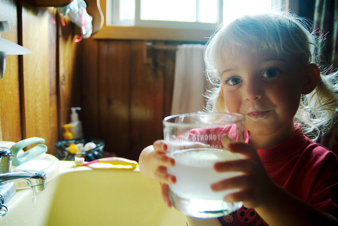 Little Girl Brushing her Teeth with a Glass of Water, Lake Muskoka, Bracebridge, Ontario