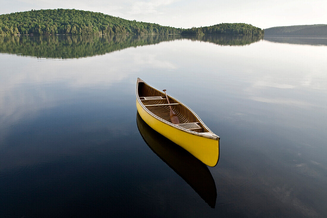 Yellow canoe floating on Smoke Lake, Algonquin Park, Ontario