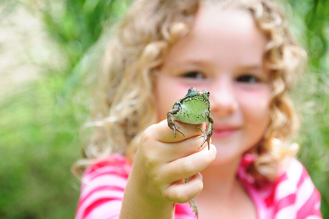 Little girl holding a frog, Simcoe, Ontario