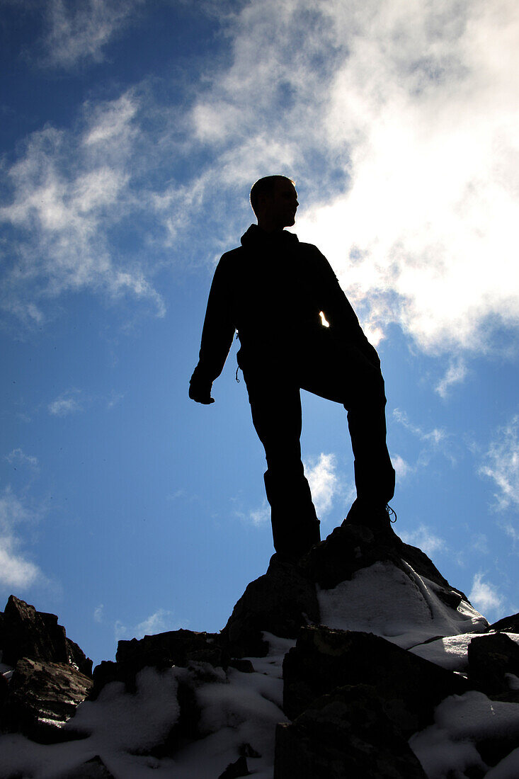 Silhouette of man standing on a mountain summit, Tombstone Territorial Park, Yukon