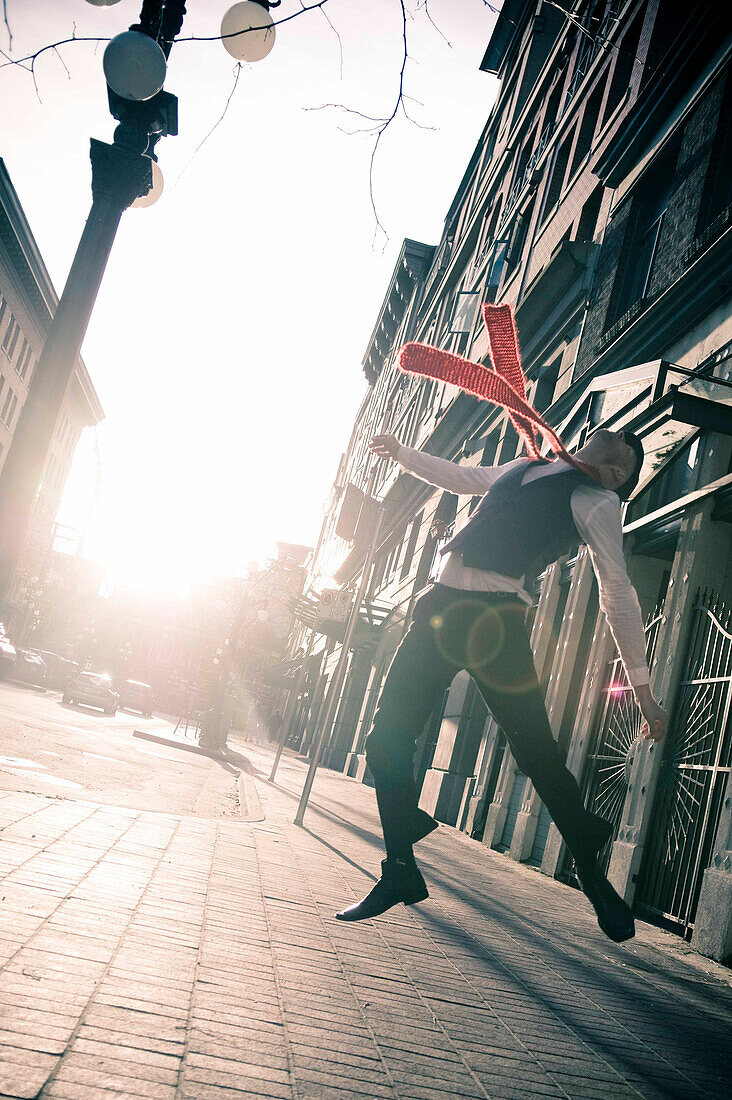 Stylish businessman jumping in the street, Gastown, Vancouver, British Columbia