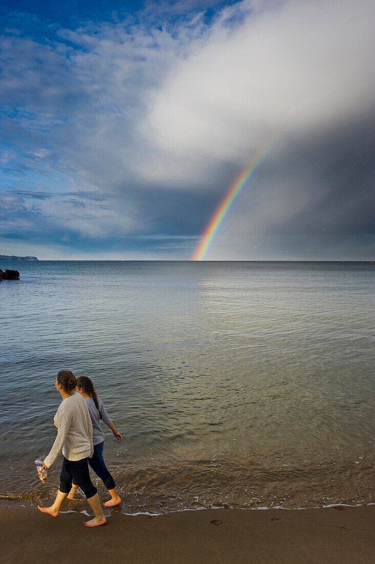 Mother and daughter walking along the beach, beach and rainbow near L´Escala, Costa Brava, Costa Brava, Spain